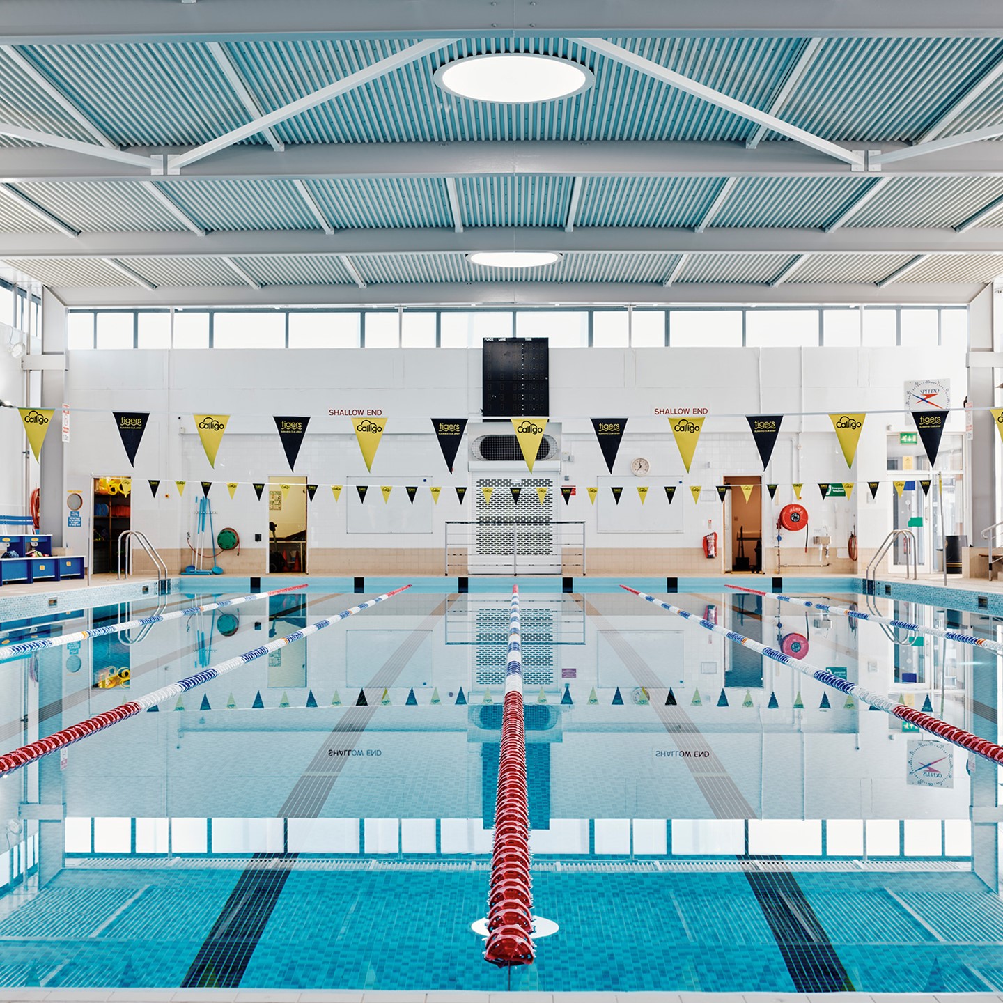 Swimming pool with yellow and black flags above the water