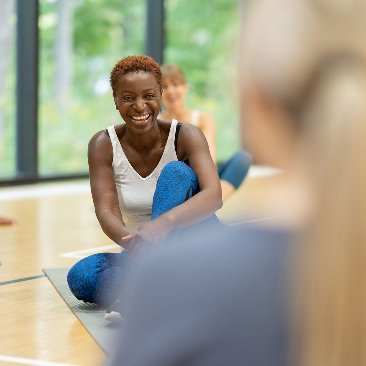 Woman doing yoga on floor mat in group class