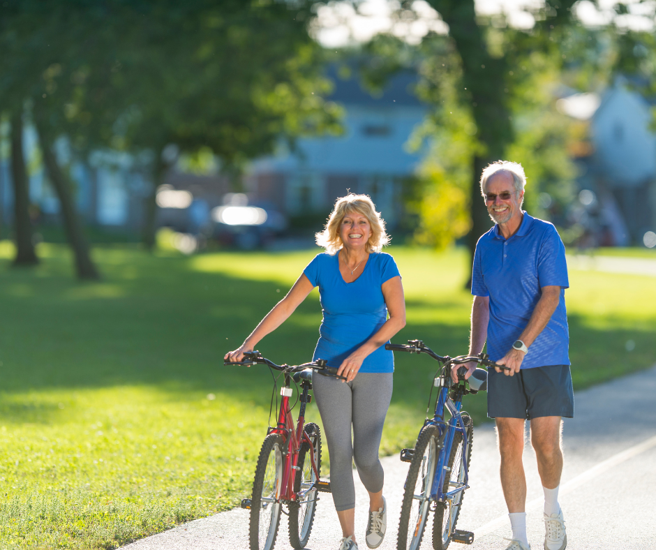 Photo of two people walking on a path with their bikes
