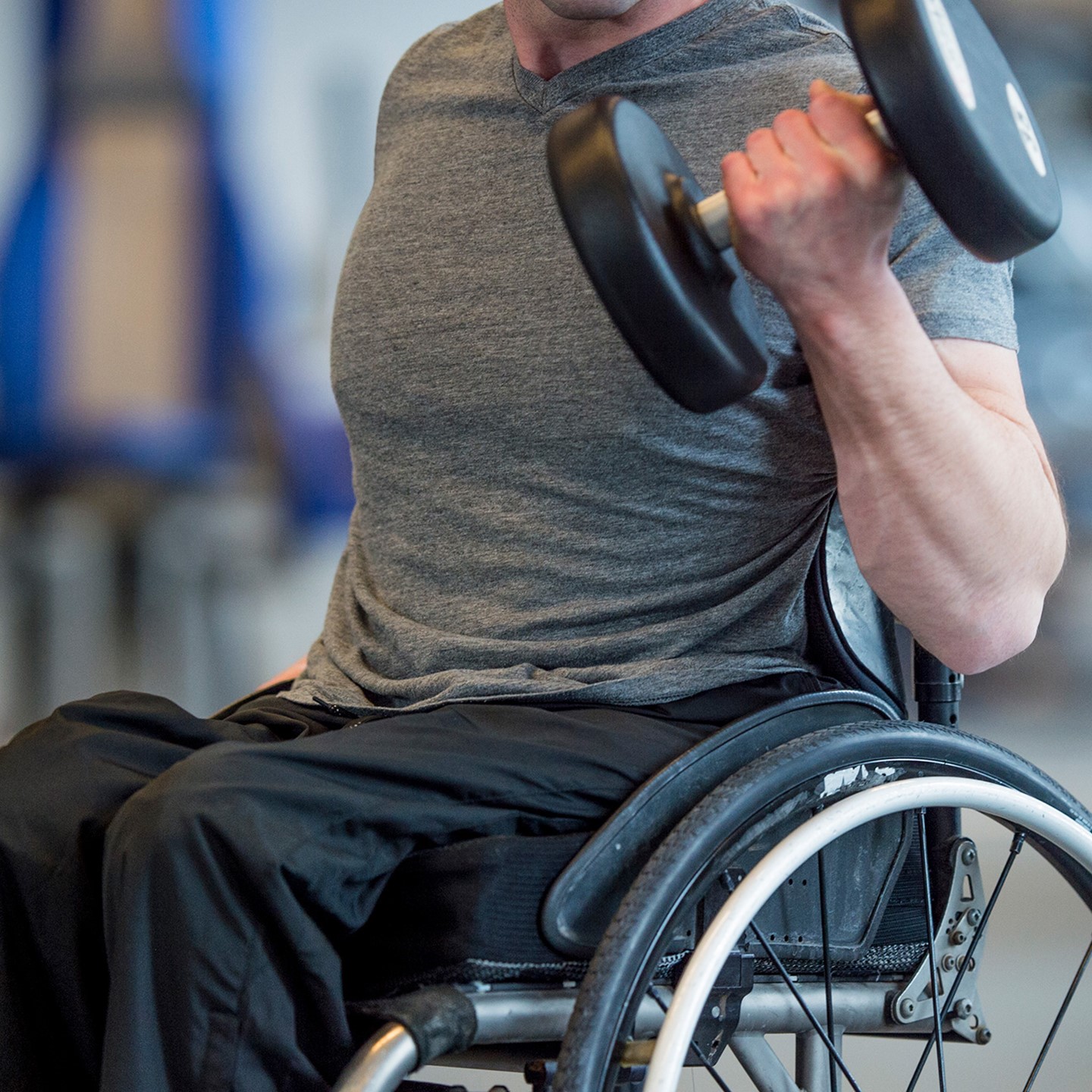 Disabled man lifting dumbbells in a wheelchair